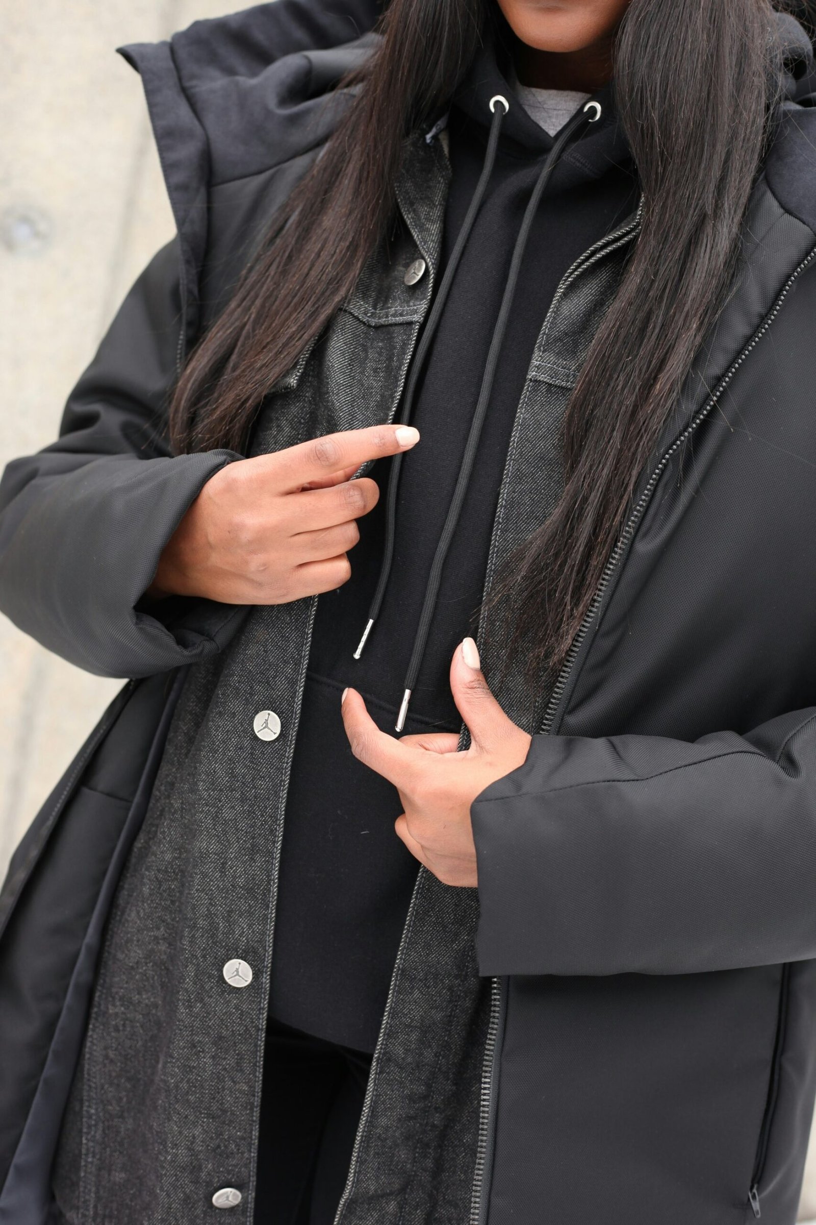 woman in black coat holding her chin